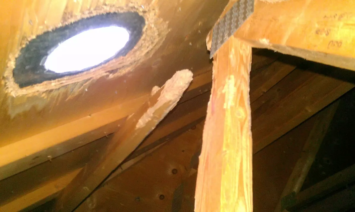 An attic with light showing through a squirrel entry hole