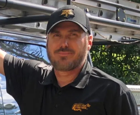 The owner of Critter Control of Central Mississippi in a Critter Control shirt and cap